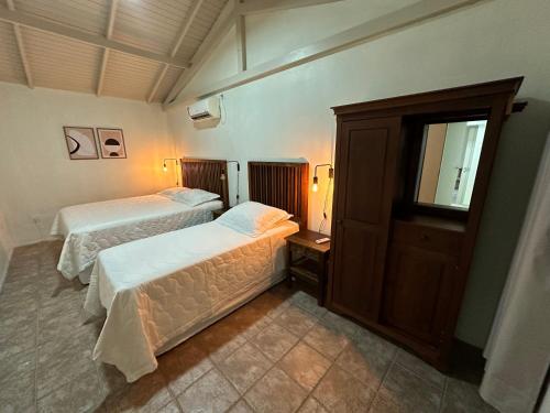 a hotel room with two beds and a mirror at Barra Velha - Itajuba Beach House in Itajubá