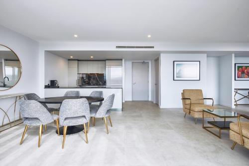 a kitchen and dining room with a table and chairs at Meriton Suites Canberra in Canberra