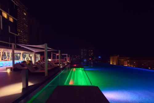 a swimming pool at night with chairs and a building at Cinnamon Life at City of Dreams in Colombo