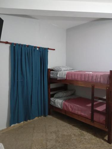 a room with two bunk beds and a blue curtain at Los Cactus 2 in La Rioja