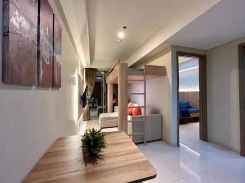a living room with a table and a bedroom at Gold Coast Apartment PIK Luxury Sea View by stay with E in Jakarta