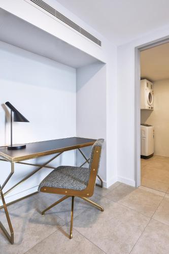 a desk and a chair in a room at Meriton Suites Canberra in Canberra
