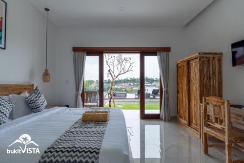 a bedroom with a bed and a sliding glass door at Agra Villa Bali by Bukit Vista in Uluwatu