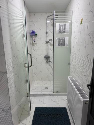 a shower with a glass door in a bathroom at Samarkand Hostel in Samarkand