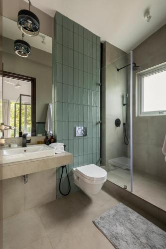 a bathroom with a toilet and a sink and a shower at La Olalian 2 & 3 BHK Designer Villas Near Anjuna Beach with Private Pool & Sun Deck & Garden in Anjuna