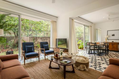 a living room with a couch and a table at La Olalian 2 & 3 BHK Designer Villas Near Anjuna Beach with Private Pool & Sun Deck & Garden in Anjuna
