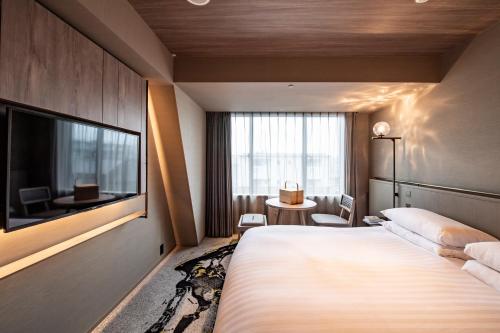 a hotel room with a large bed and a television at THE HOTEL HIGASHIYAMA KYOTO TOKYU, A Pan Pacific Hotel in Kyoto