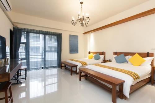 a bedroom with two beds and a desk at Hualien Professor's Home B&B No. 2198 in Jian