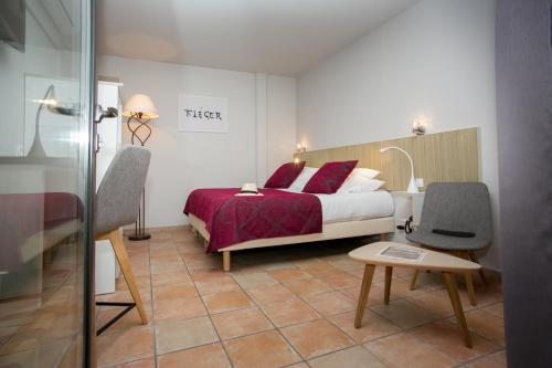 a bedroom with a bed and a table and a chair at Le Relais Des Trois Mas in Collioure