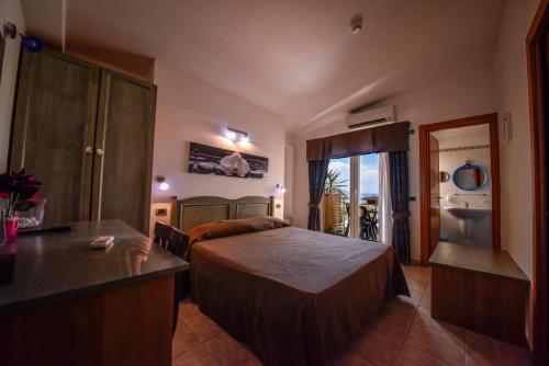 a hotel room with a bedroom with a bed and a kitchen at Hotel La Villa in Corigliano Calabro