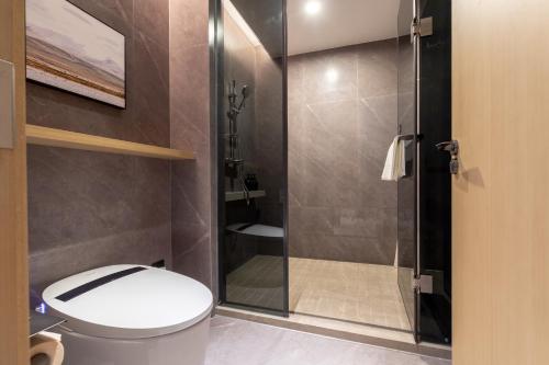 a bathroom with a toilet and a glass shower at Atour Hotel Wuhan Hankou Railway Station South Plaza in Wuhan