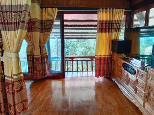 - un salon avec des rideaux et une grande fenêtre dans l'établissement Homestay phố núi suối giàng, à Yên Bái