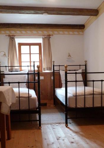 two beds in a bedroom with a window at Landhaus Strickenmacher in Sillian