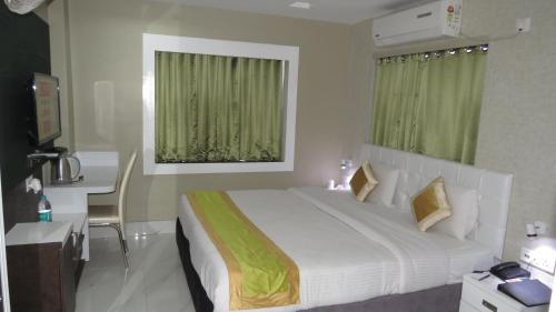 a bedroom with a bed and a desk and a window at Geetanjali International in Deoghar
