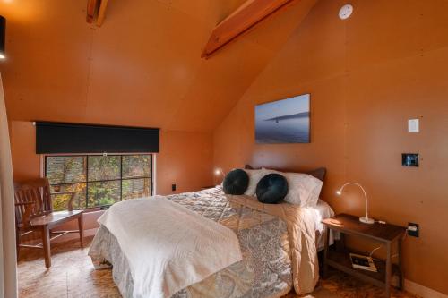 a bedroom with orange walls and a bed and a window at Water Mtn Views, Forest Walk To Beach! in Clinton