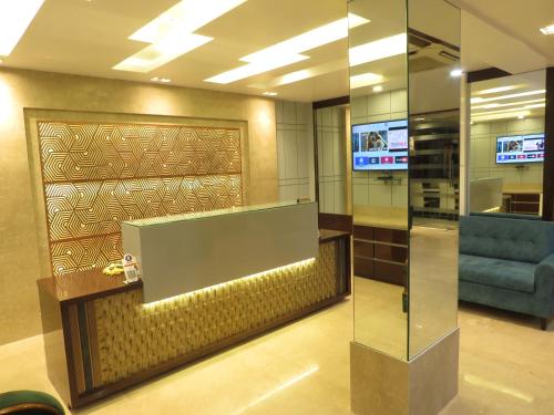 a lobby with a glass partition and a blue couch at Geetanjali International in Deoghar