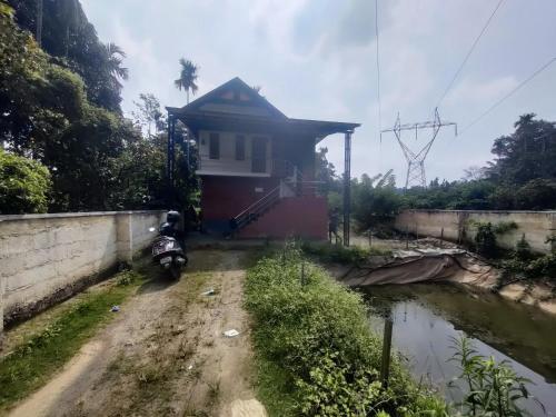 a house with a motorcycle parked in front of it at Private Cottage Wayanad in Kalpetta
