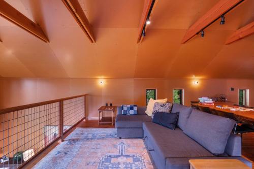 a living room with a couch and a table at Water Mtn Views, Forest Walk To Beach! in Clinton