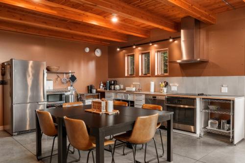 a kitchen with a black table and chairs at Water Mtn Views, Forest Walk To Beach! in Clinton