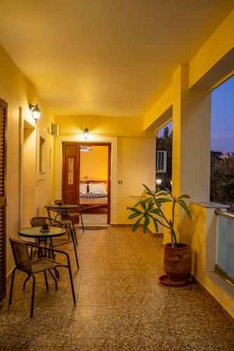 a room with tables and chairs and a television at Olive Studios Karpathos Studio #1 in Karpathos Town