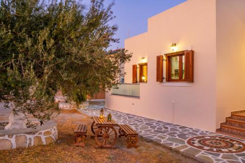 a courtyard of a house with a table and a tree at Olive Studios Karpathos Studio #1 in Karpathos Town