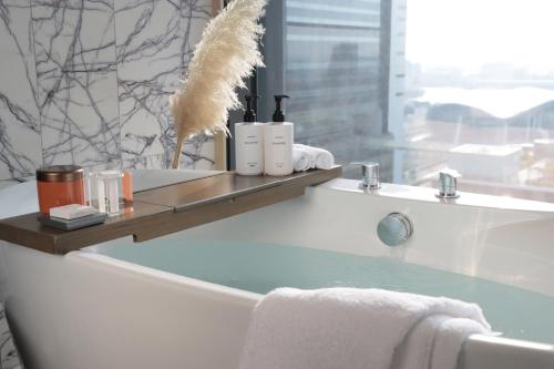 a bathroom with a bath tub with a shelf with towels at InterContinental Kaohsiung by IHG in Kaohsiung
