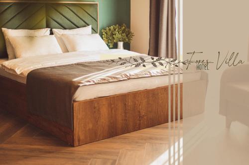 a bedroom with a large bed with a wooden headboard at Forest Villa in Goderdzi