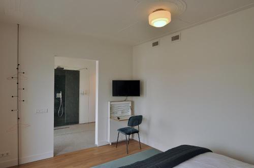a bedroom with a bed and a chair and a desk at Boetiek Hotel Kampen in Kampen