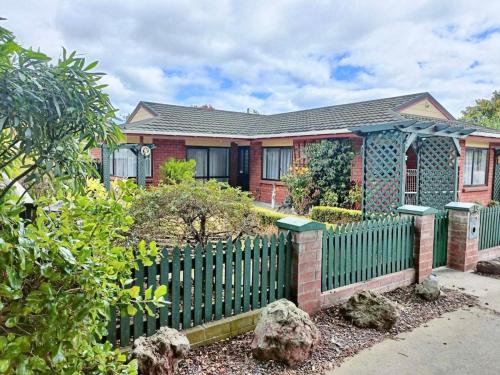 a house with a green fence in front of it at Balgownie Estate in Whanganui
