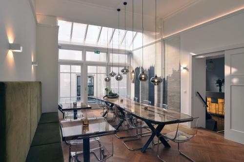 een eetkamer met een lange tafel en stoelen bij Boetiek Hotel Kampen in Kampen