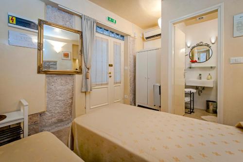 a bedroom with a bed and a mirror and a door at Guest house SOTTO I VOLTI Centro Storico in Rovinj