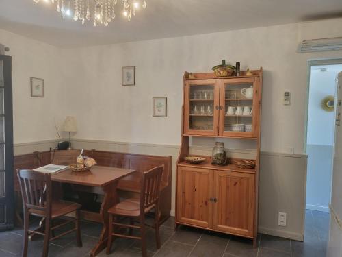 een eetkamer met een tafel en een houten kast bij I Mucchi in Galeria