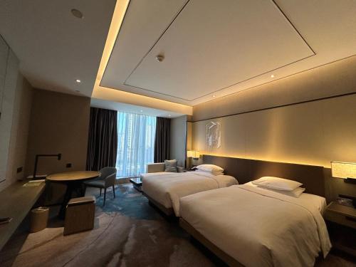a hotel room with two beds and a table at Hangzhou Marriott Hotel Lin'an in Lin'an