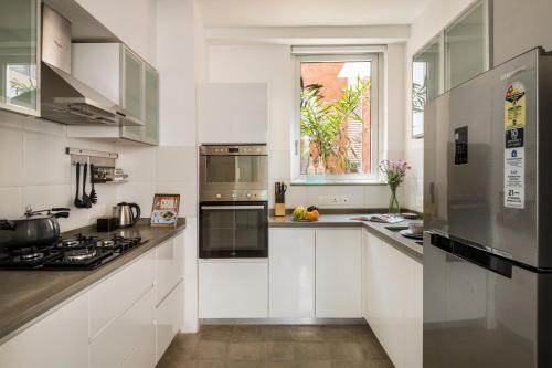 a kitchen with white cabinets and stainless steel appliances at La Olalian 2 & 3 BHK Designer Villas Near Anjuna Beach with Private Pool & Sun Deck & Garden in Anjuna