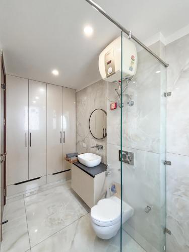 a bathroom with a toilet and a glass shower at Housr Sector 43 Gurgaon Near One Horizon Centre in Gurgaon