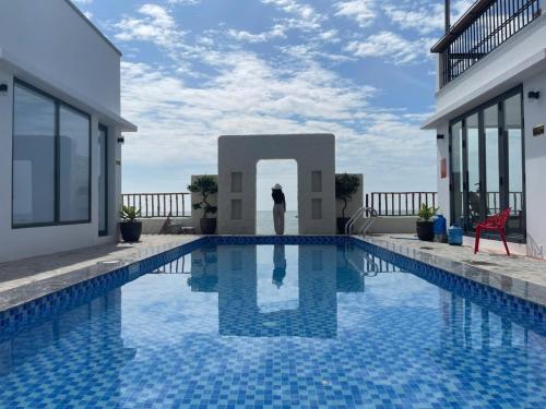 a person standing next to a swimming pool at Seaside Mui Ne Hotel in Mui Ne