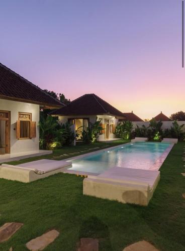 a villa with a swimming pool in front of a house at Villa Maja Bingin Boutique Hotel in Uluwatu