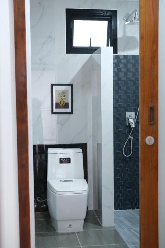 a bathroom with a white toilet and a window at Alisse Stay Phuket Layan in Phuket