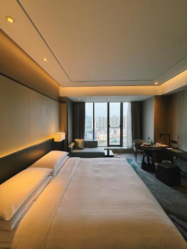 a large bed in a room with a large window at Hangzhou Marriott Hotel Lin'an in Lin'an
