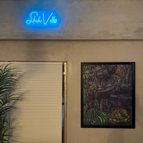 a sign above a door with a painting on the wall at Shiki Villa Beppu in Beppu