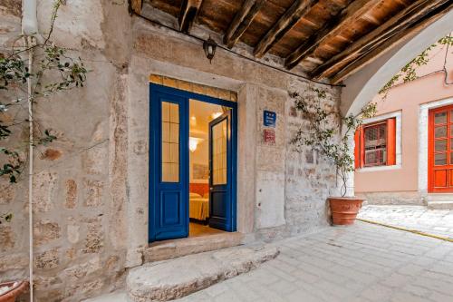 a blue door in a stone house with a patio at Guest house SOTTO I VOLTI Centro Storico in Rovinj
