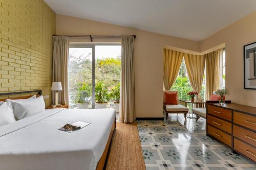 a bedroom with a large bed and a large window at La Olalian 2 & 3 BHK Designer Villas Near Anjuna Beach with Private Pool & Sun Deck & Garden in Anjuna
