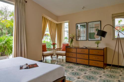 a bedroom with a bed and a dresser and a desk at La Olalian 2 & 3 BHK Designer Villas Near Anjuna Beach with Private Pool & Sun Deck & Garden in Anjuna