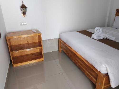 a small bedroom with a bed and a wooden cabinet at Nan Bungalows Tetebatu in Tetebatu