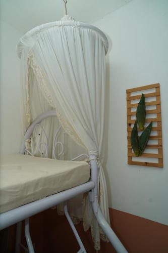 a white chair with a curtain in a room at ROCCA Del GARDA Residences in Binangonan