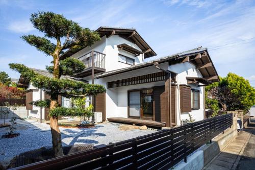 a house with a tree in front of it at まるまる貸切 月隈雅居 Tsukiguma-yaju 最大9名宿泊可 in Fukuoka