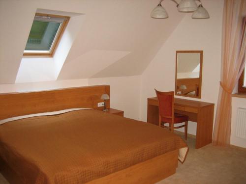 a bedroom with a bed and a desk and a mirror at Hotel Bazant in Karlovy Vary