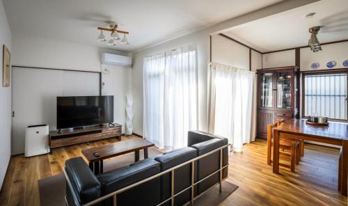 a living room with a couch and a table at まるまる貸切 月隈雅居 Tsukiguma-yaju 最大9名宿泊可 in Fukuoka