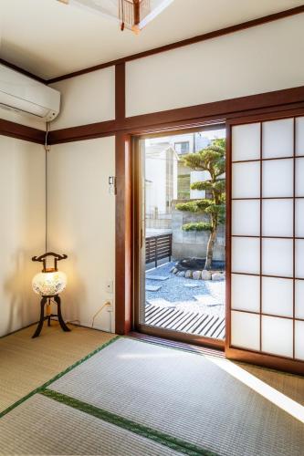 a room with a large sliding glass door at まるまる貸切 月隈雅居 Tsukiguma-yaju 最大9名宿泊可 in Fukuoka