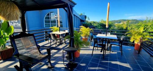a patio with tables and chairs on a balcony at ROCCA Del GARDA Residences in Binangonan